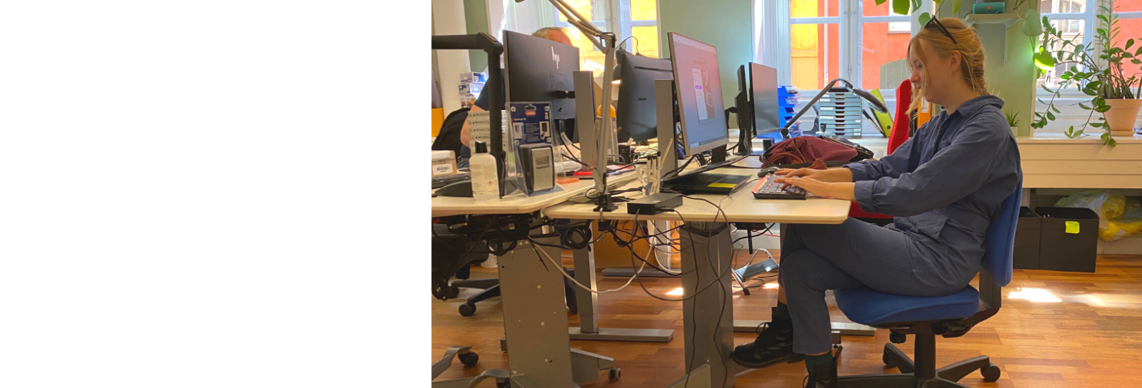 En person sidder og arbejder ved et skrivebord